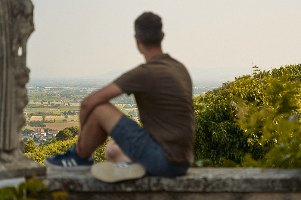 ragazzo seduto con vista panoramica di Breganze e dintorni da ca delle ore